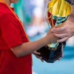Man Giving A Trophy To A Child